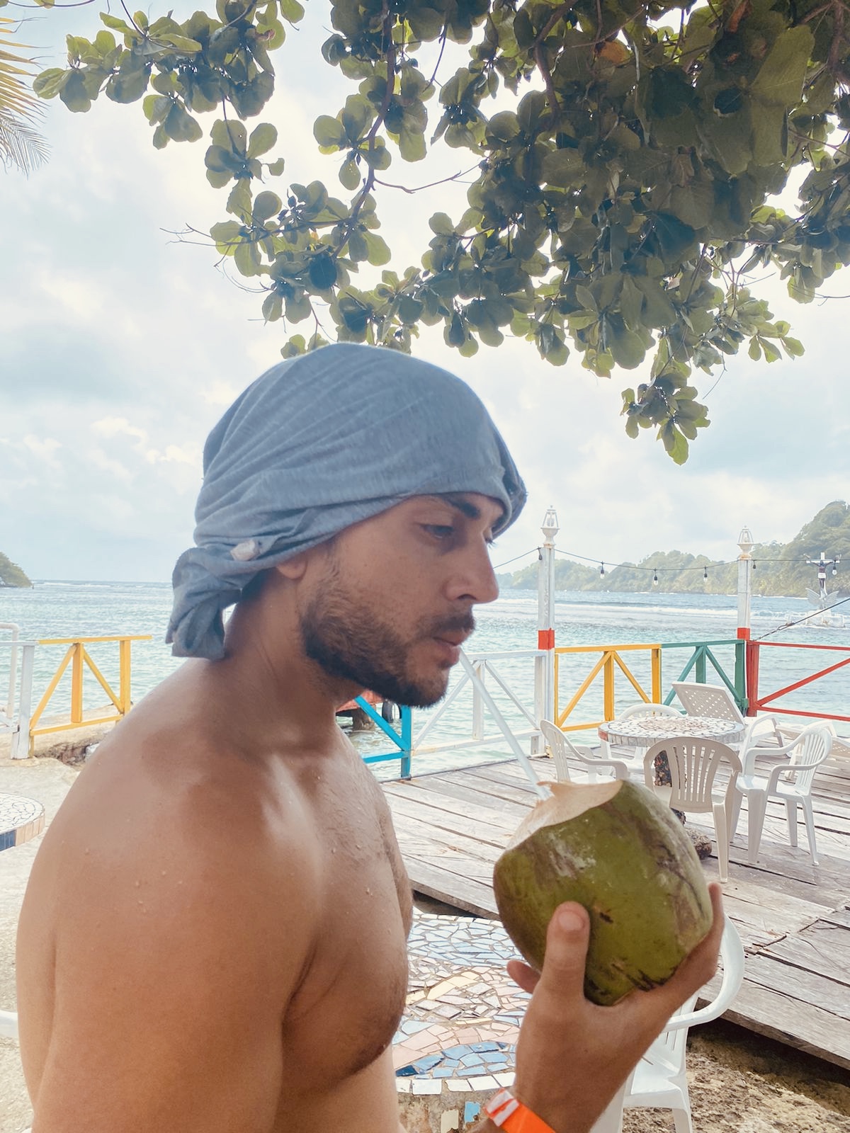 Sean Ali holding a coconut at the beach