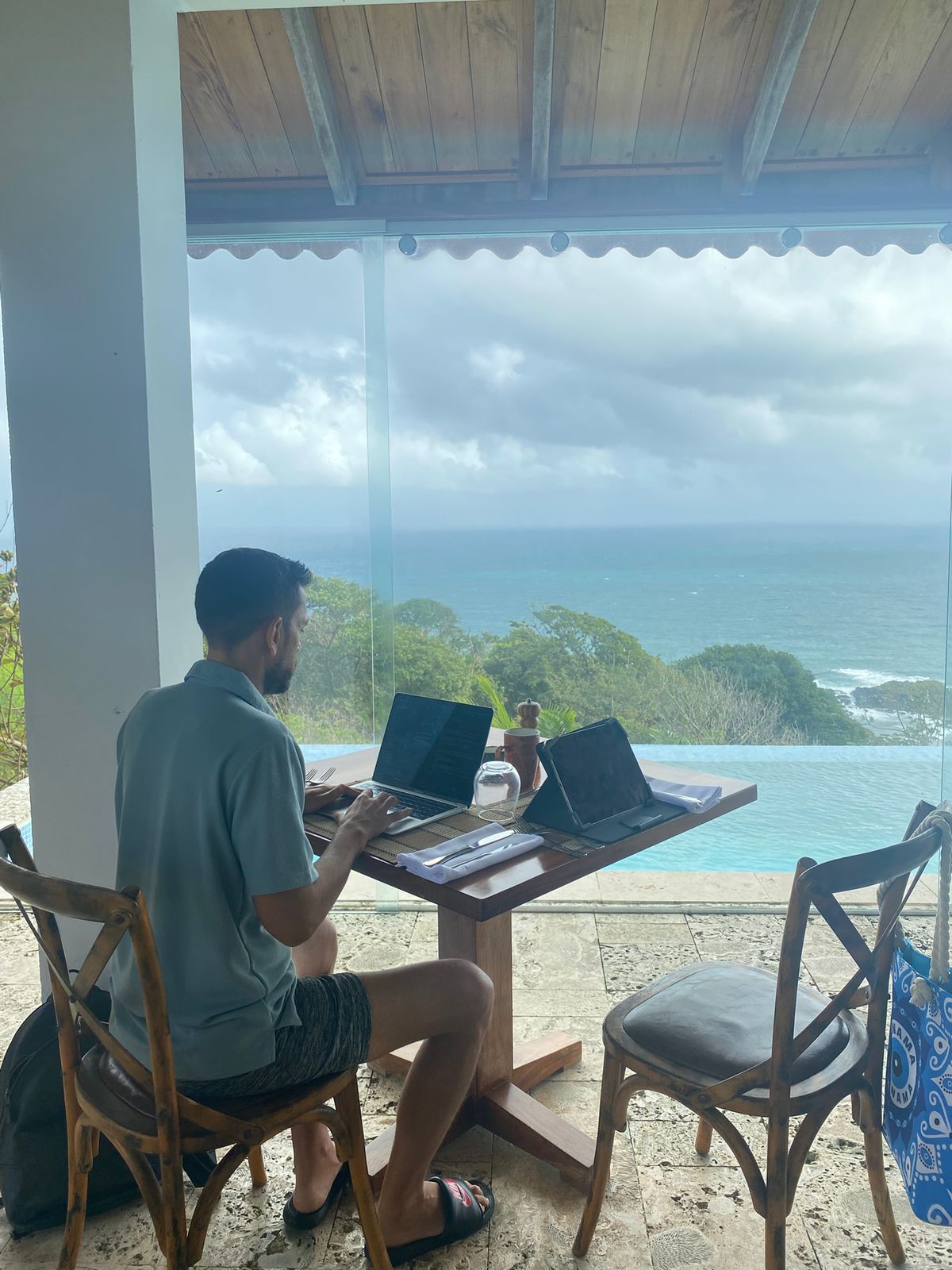 Sean Ali working from a laptop with an ocean view